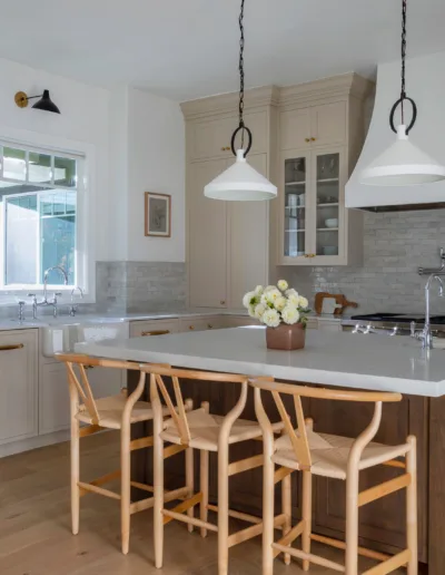 A kitchen with a center island and stools.