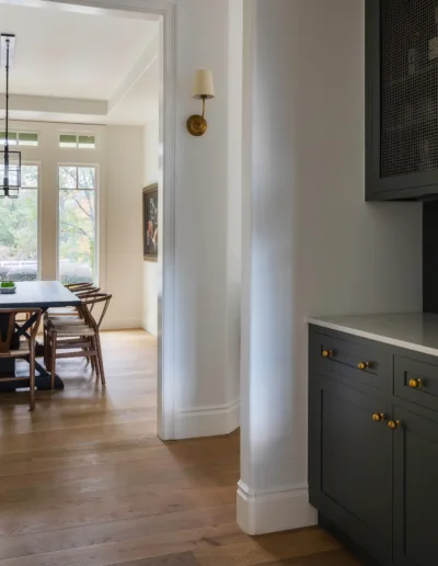 A kitchen with black cabinets and a wooden floor.