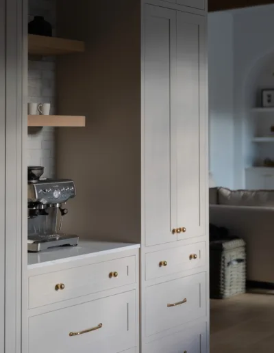 A kitchen with white cabinets and a coffee maker.