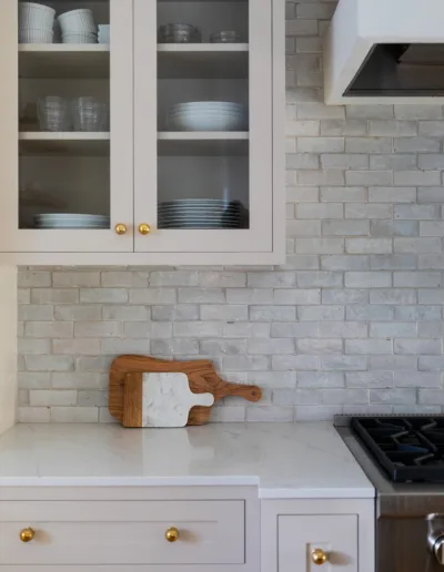 A white kitchen with white cabinets and gold hardware.