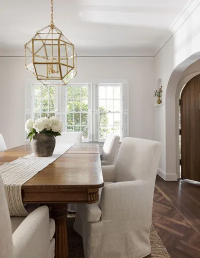 A dining room with a white table and chairs.