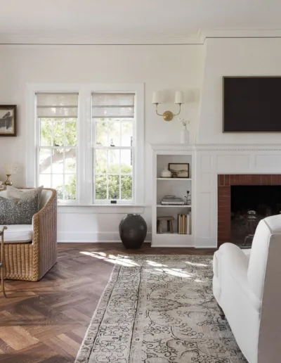 A white living room with wicker furniture and a fireplace.