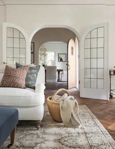 A living room with a white couch and a rug.