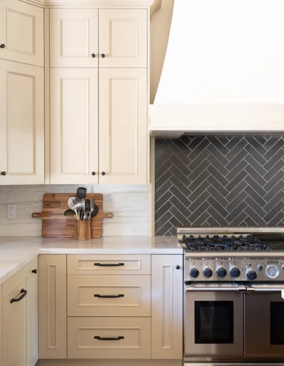 A kitchen with white cabinets and a stove.