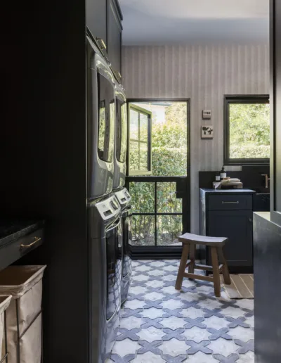 A black and white laundry room with a tiled floor.